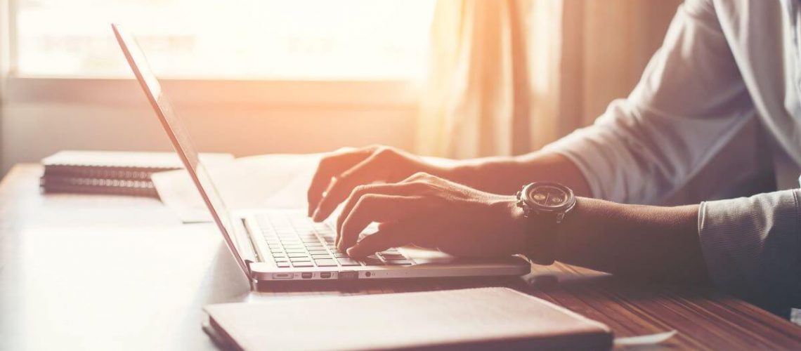 close-up-of-male-hands-using-laptop-in-home